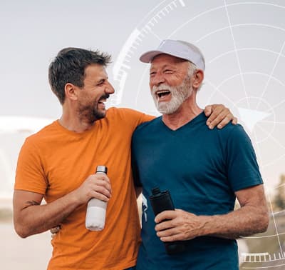 Dois homens seniores abraçados sorrindo ao ar livre
